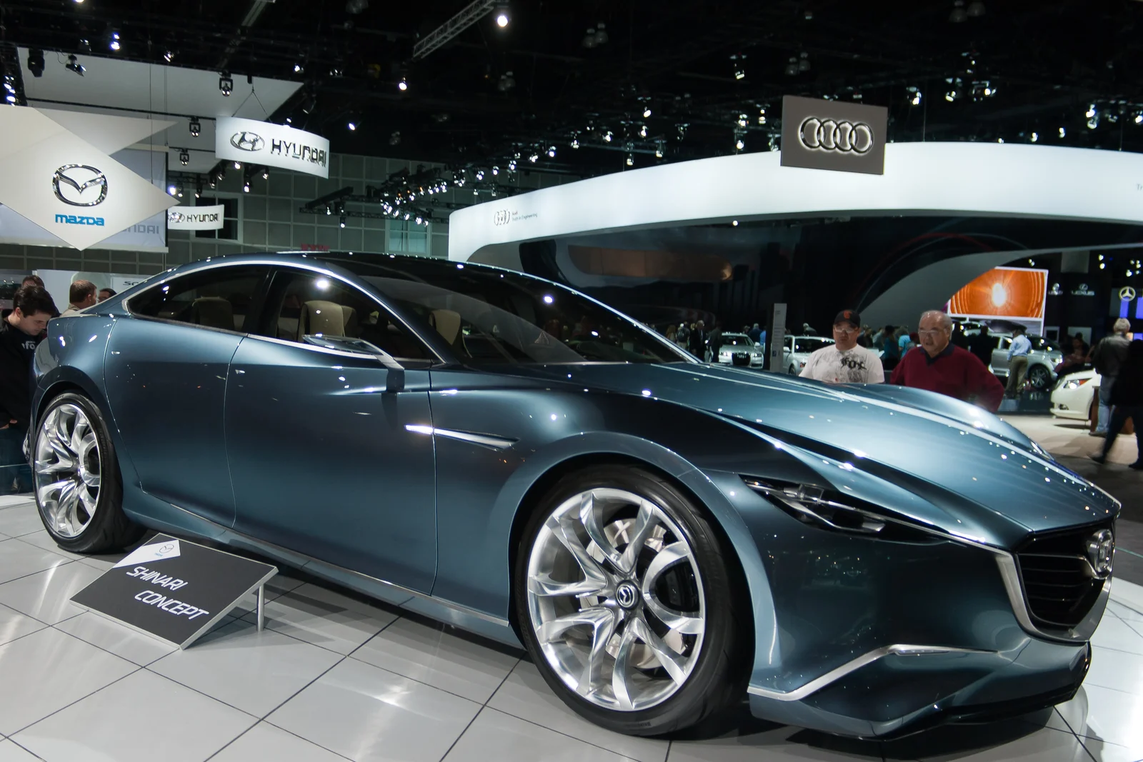 蓝色 Mazda SHINARI 概念车在展台上的前侧视图。