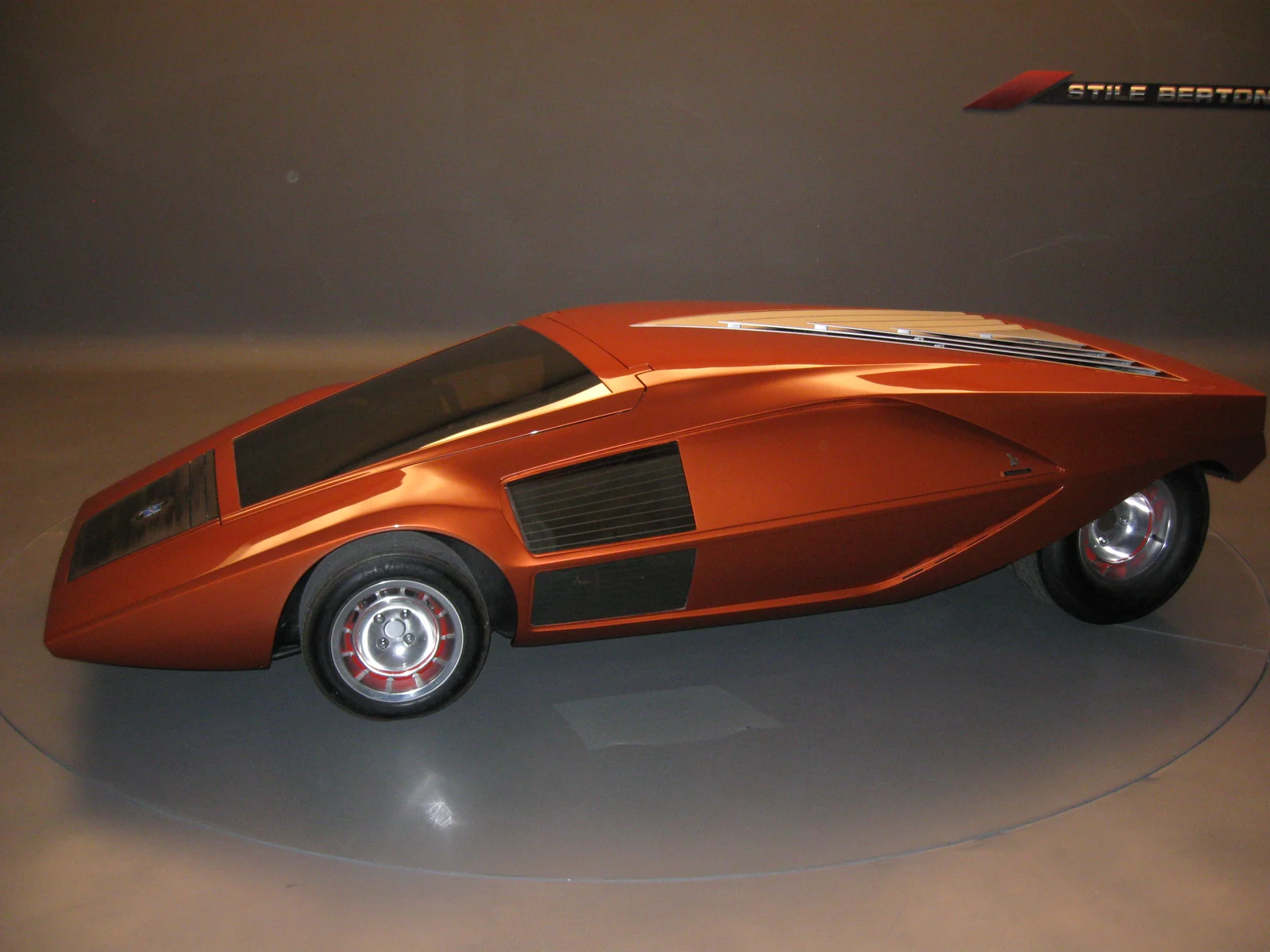 橙色 Lancia Stratos Zero 在博通展厅的侧面全车视图。